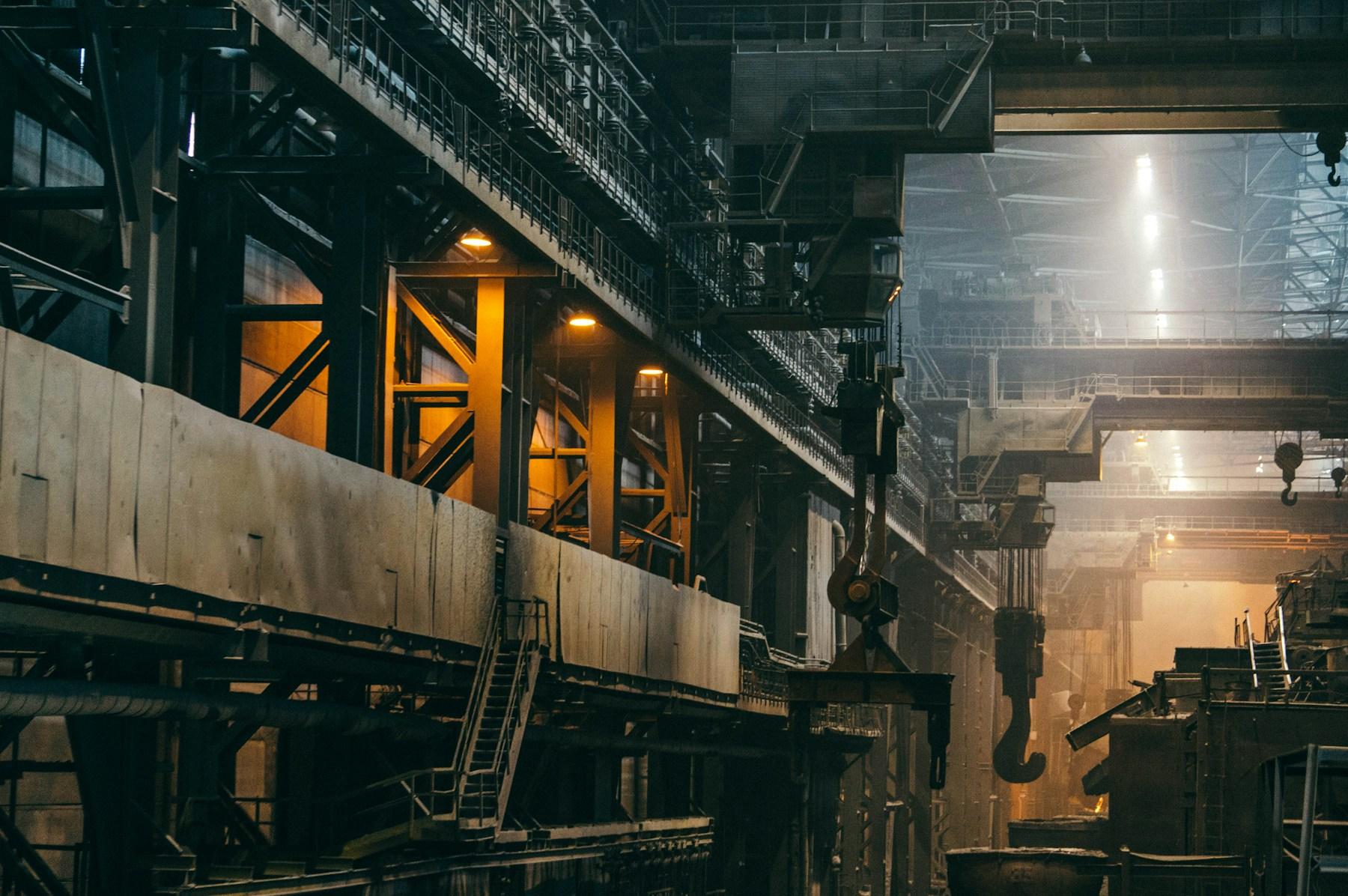 Overhead cranes and heavy machinery inside an industrial production plant